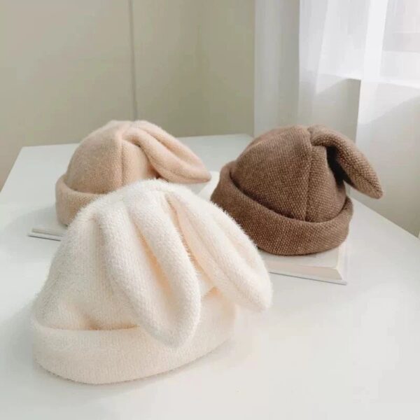 کلاه بچگانه با طرح گوش خرگوش نمدی و نرم، مناسب برای هوای سرد و استایل کودکانه زیبا، در رنگ‌های کرم، قهوه‌ای و سفید، به همراه جزئیات فانتزی و راحتی در استفاده.